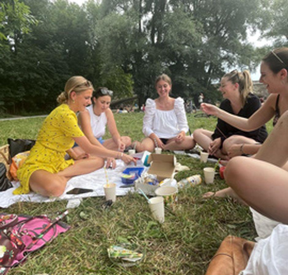 Reachbird Team sitzt zusammen auf einer Wiese in München und genießt das gute Wetter