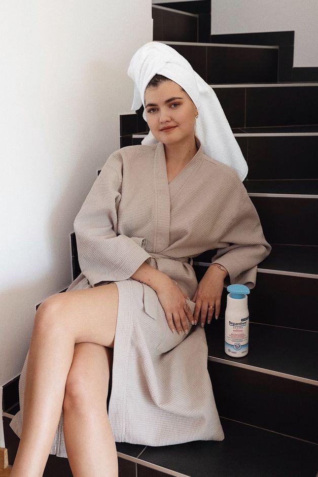 women in a bathrobe sitting on a staircase