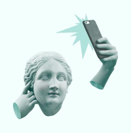 Classical statue head with a detached arm taking a selfie, set against a light background.