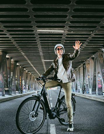 Man riding his bike and waving