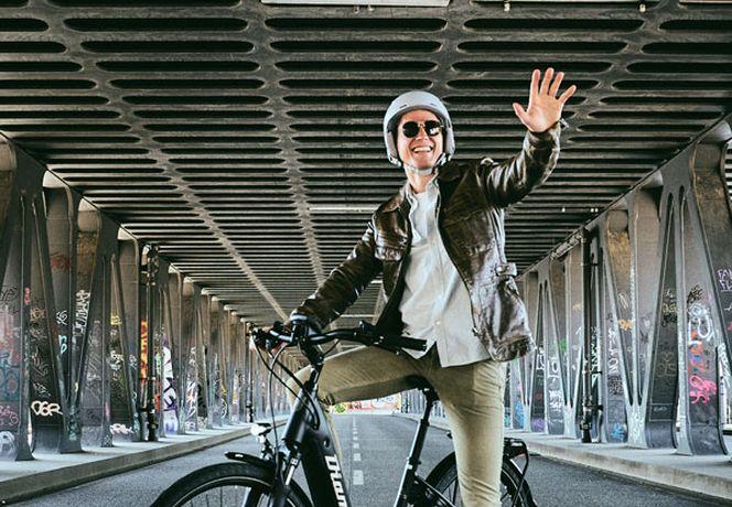 Man riding his bike and waving