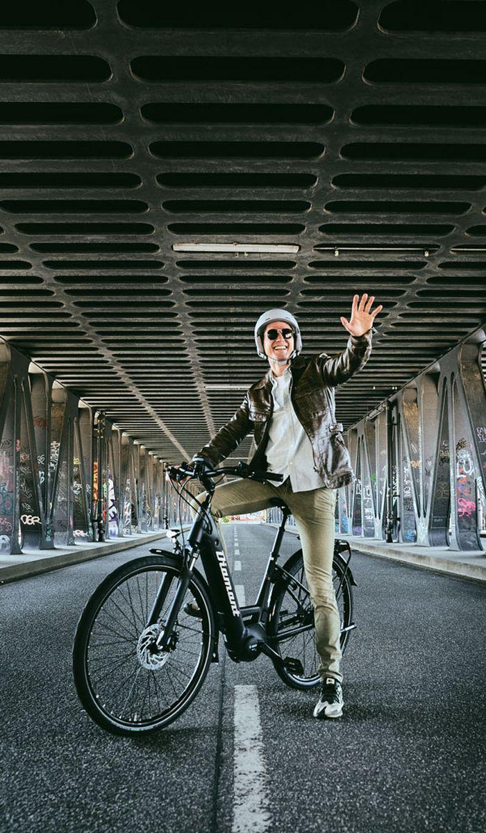 Man riding his bike and waving