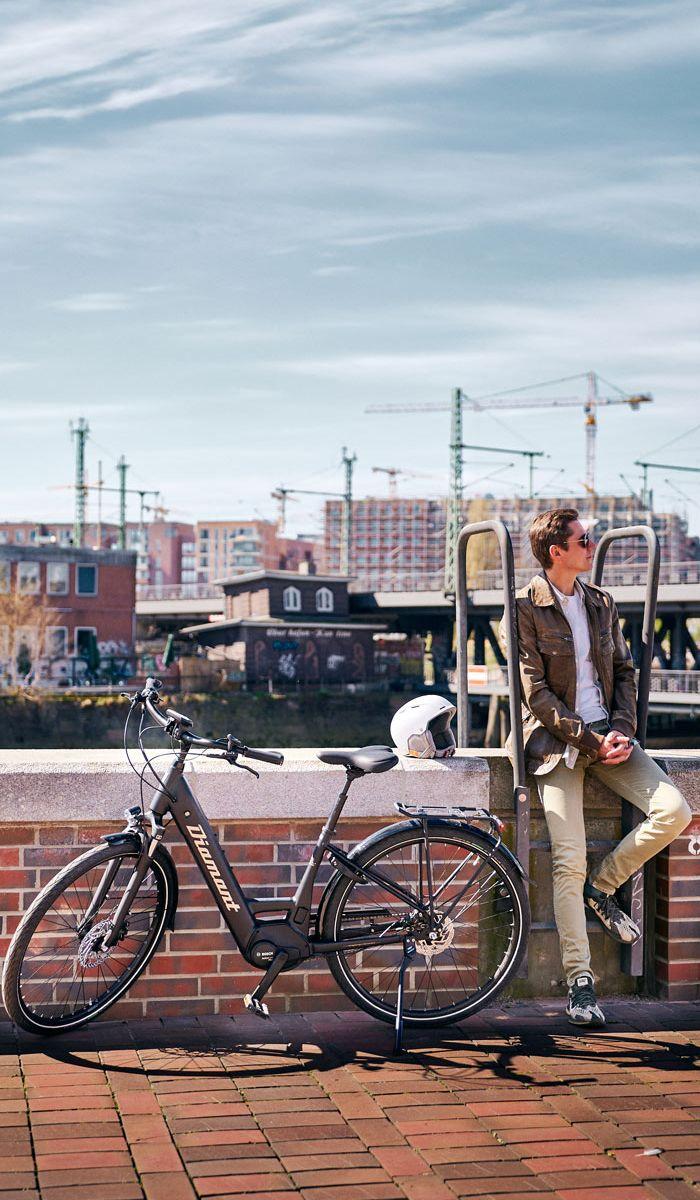 man sitting an a wall next to his bike